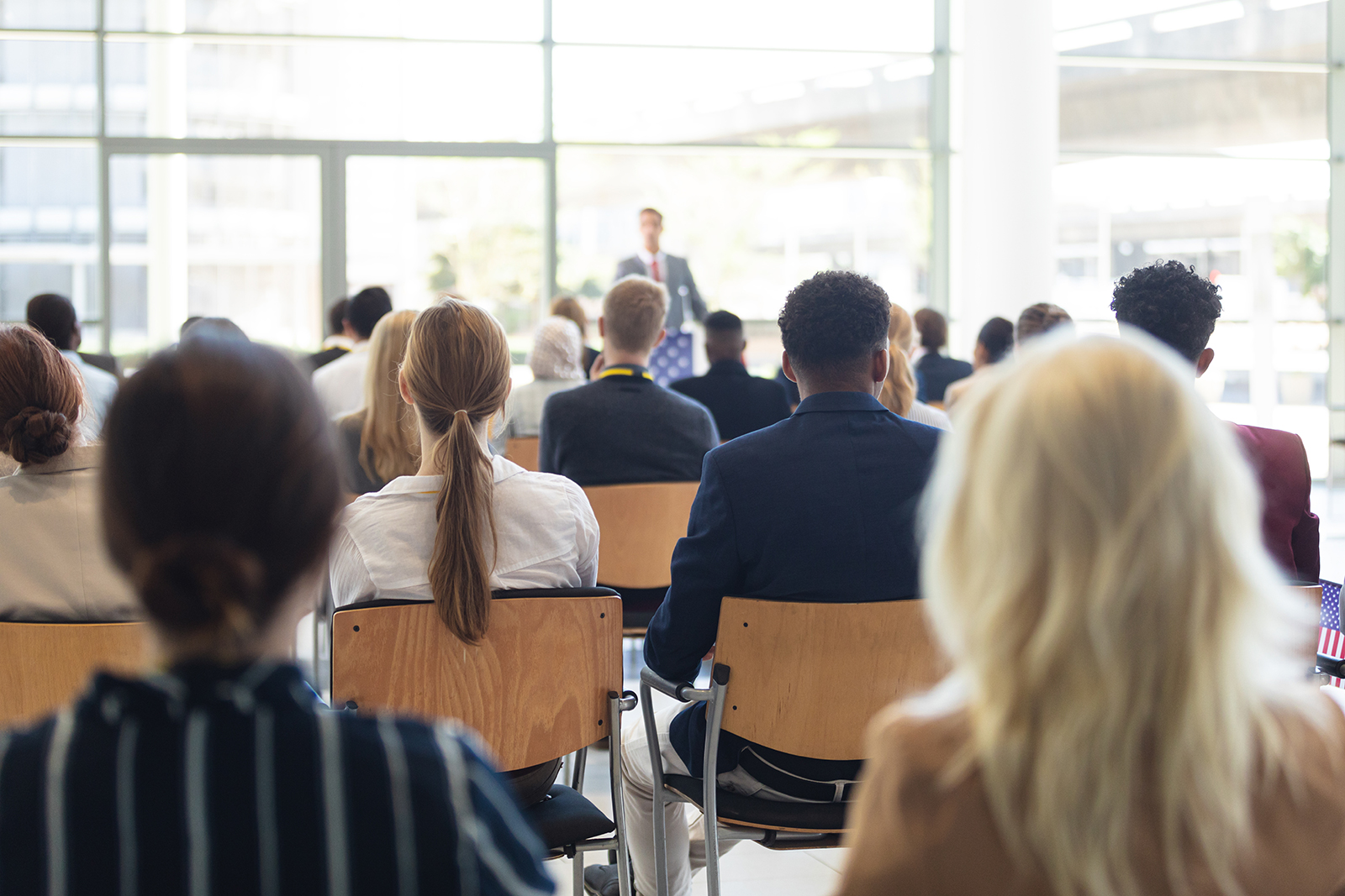 People sitting and listening to a speaker at a conference